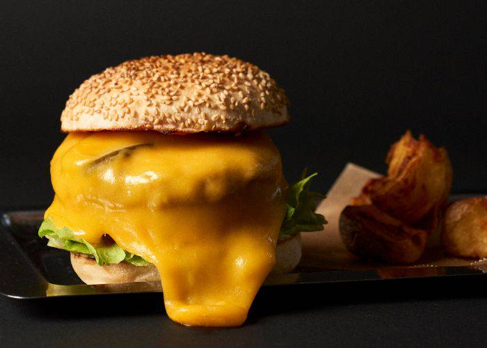 A cheeseburger from Jiyugaoka Burger, featuring a sesame bun and burger topped with gooey cheese,